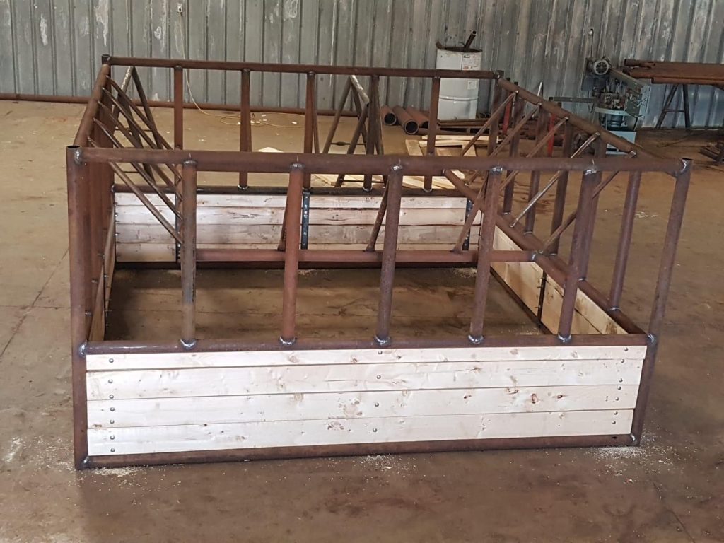 double hay bale feeder made of wood planks and metal framing