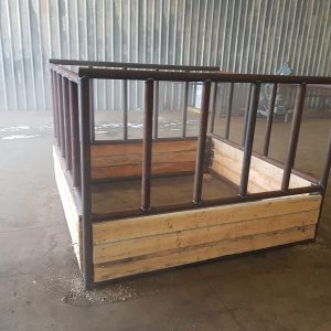 double hay bale feeder made of wood planks and metal framing